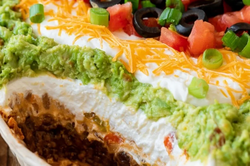 Delicious 7 layer dip with colorful layers of beans, cheese, and toppings.