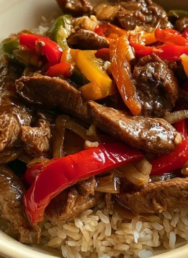Cozy slow cooker pepper steak served with rice and vegetables.