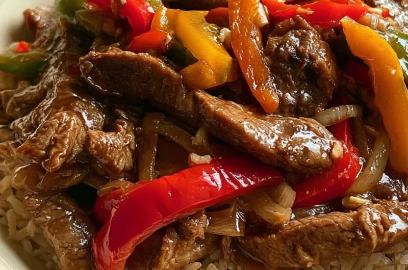 Cozy slow cooker pepper steak served with rice and vegetables.