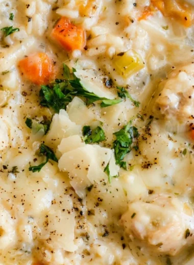 Creamy chicken and rice soup served in a bowl with herbs and spices
