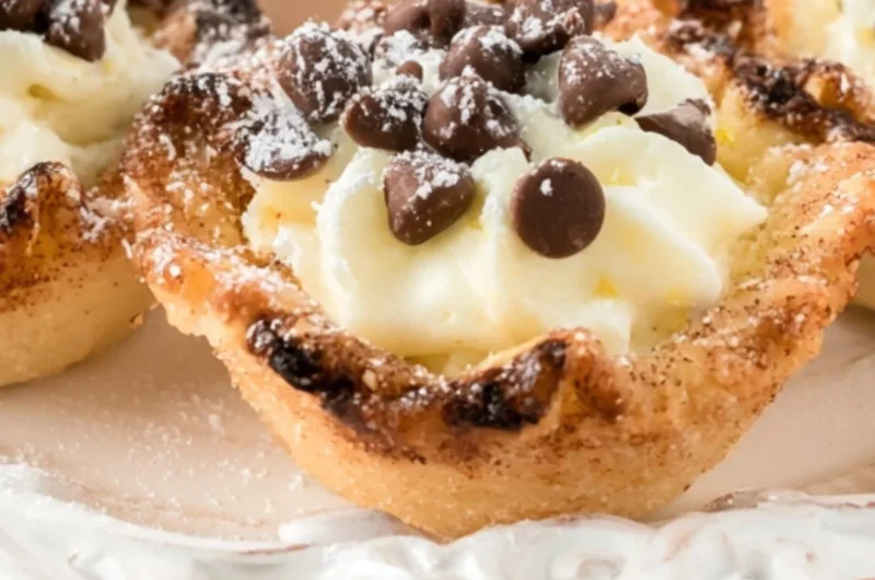Delicious creamy mini cannoli cups topped with chocolate and powdered sugar.