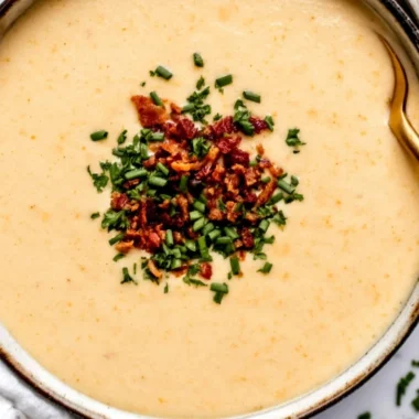 Bowl of high-protein cream of protein soup garnished with herbs.