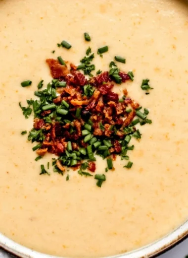 Bowl of high-protein cream of protein soup garnished with herbs.