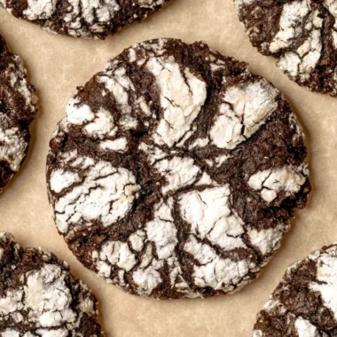 Delicious chocolate crinkle cookies dusted with powdered sugar on a white plate