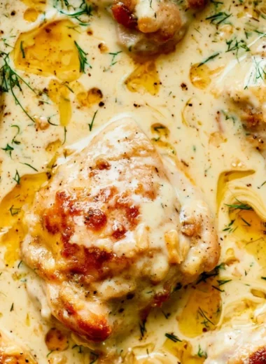 Creamy oven baked chicken thighs served on a plate with herbs