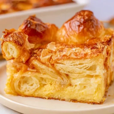 Delicious croissant French toast bake served with syrup and berries.