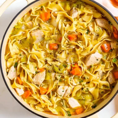 Bowl of Dutch Oven Chicken Noodle Soup with fresh herbs and vegetables