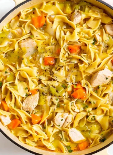 Bowl of Dutch Oven Chicken Noodle Soup with fresh herbs and vegetables