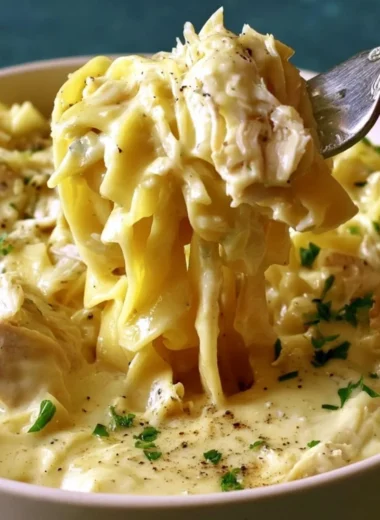 Bowl of easy creamy chicken and noodles garnished with herbs