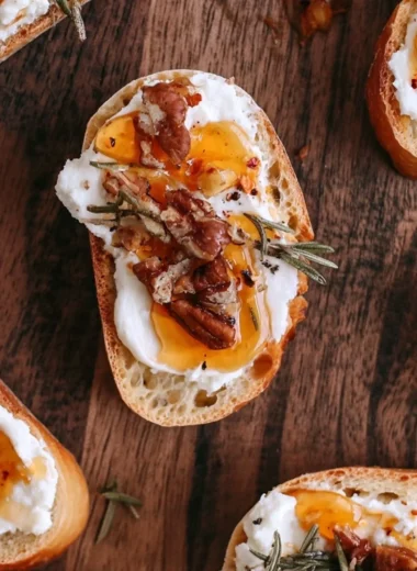 Delicious whipped feta crostini drizzled with hot honey on a wooden platter